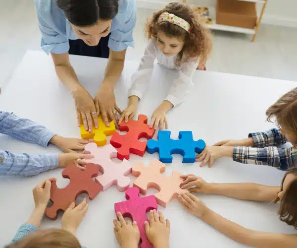 Enfants de primaire coopérant autour d’un puzzle géant, lors d’une activité ludique et éducative de type escape game