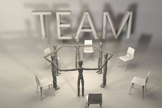 Mannequins en cercle, chaises autour, "TEAM" écrit.